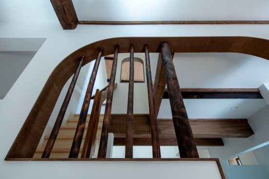 Detail of the arched opening with brushed charred cedar log bars