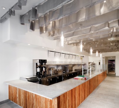 Vic’s Bagel Bar in Manhattan (now closed) includes a custom ruffled-mesh metal ceiling installation that spans the length of the restaurant, diffusing light and masking the irregular ceiling above.