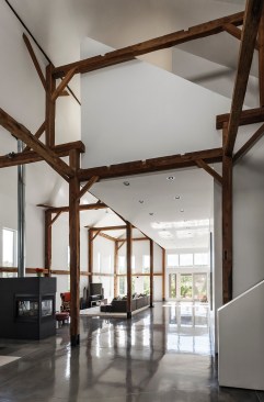 I-Kanda wove habitable volumes around the exposed wooden frame of a mid-19th-century horse barn in Sterling, Mass., to facilitate loft-like living in a historical structure.