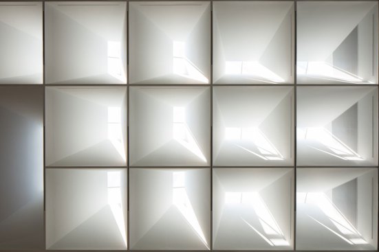 Detail of the atrium ceiling. The specific orientation of the skylight "modules" and the resulting differentiation in direct daylight patterning transforms the ceiling into a dynamic composition that responds to changing sky and light conditions outside.