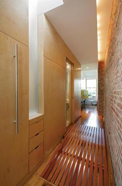 Helping the small apartment live large are storage spaces carved out of the raised floor deck.