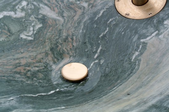 Detail of the drinking fountain’s basin made of marble and brass elements.