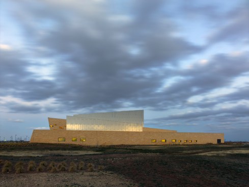 The main volume is clad in indigenous rough-hewn limestone
