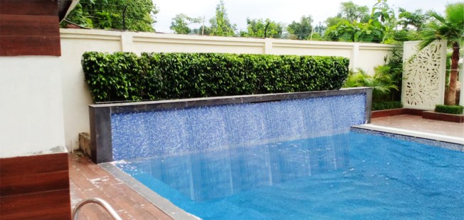 Swimming pool with water cascading fall