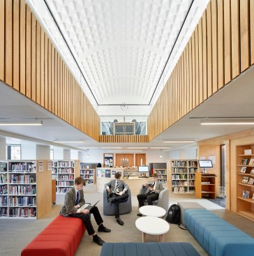 The library features a double-height space topped with a narrow, coffered arch.