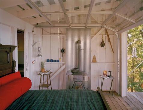 Exposed wall and roof framing highlight the modest, DIY nature of the building.