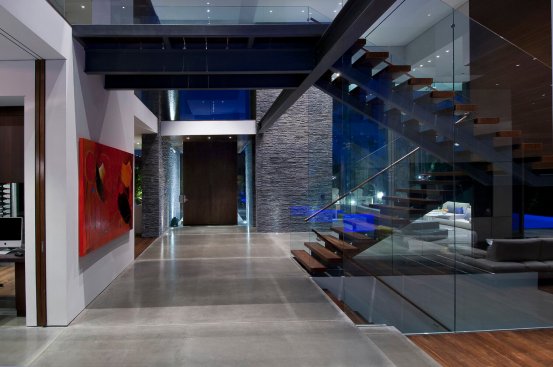Modern Beverly Hills home entry hall with glass encased staircase.