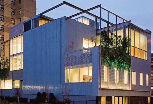 PUBLIC SPACE
A 60-foot-long, dark anthrax-zinc wall (top right) leads visitors from the street to a double-height gallery (above) at the rear of the building. The 19-foothigh gallery is illumined by north light, diffused by translucent Solera glazing panels. In the space, Affirmation Arts shows works by professional artists and hosts exhibitions and events for the surrounding community. To support these happenings, the architect installed a fully equipped art preparation area and catering kitchen behind the zinc wall.
A meticulously detailed glass stair (right) connects the gallery to second-floor offices. The curved, glassbottomed landing overlooks the Hudson Yards train gully, creating a rough-versus-refined study in contrasts. Glass fabricators Mon-X, from Montreal, built the stair from Canadian low-iron glass, and the curved panels are from Cricursa in Barcelona, Spain.