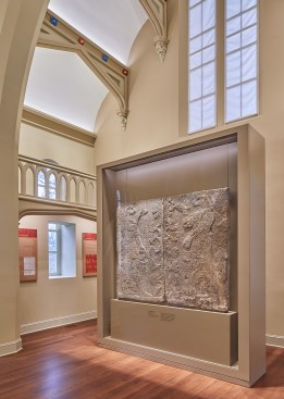 A two-sided glass case with integrated lighting offers some fill light at the top of the artifact backdrop.