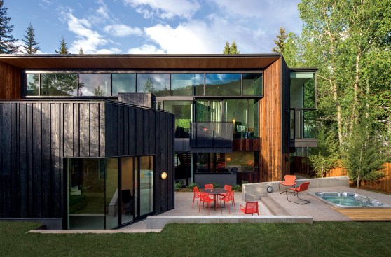 A view from the west showing the ground-floor patio and lower-height guest wing (at left).