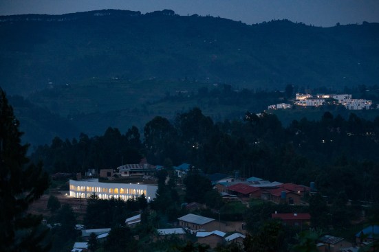 The arches of the Butaro Oncology Support Centre’s colonnades lit up at night.