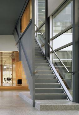 Two required fire stairs enclose the east and west edges of the central courtyard. Although occupied spaces on these elevations are generally opaque, Valerio clad the circulation spaces in glass. Energy is saved by simply tempering the air in each area to avoid extreme swings in temperature rather than providing full heating and cooling. Consistent with the rest of the building, the stairs are simply detailed in steel plate with precast terrazzo tread surfaces.