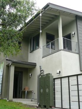 Rainwater falling on part of the front roof is collected in two Rainwater Hog catchment tanks. Unlike traditional barrels, these modular units line up neatly, flush with the wall.