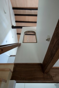 View of the staircase space, looking up the arched wall opening