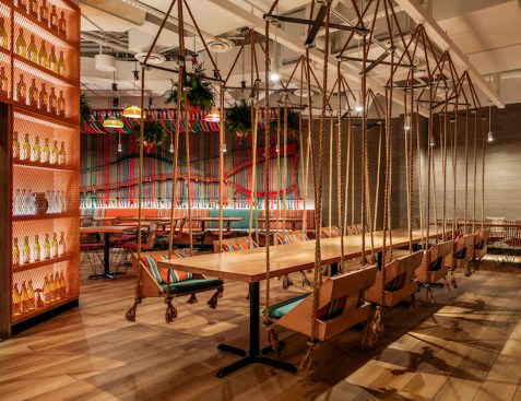 A playful, relaxed vibe was integrated into the brand by installing swinging chairs around a large wooden communal table.