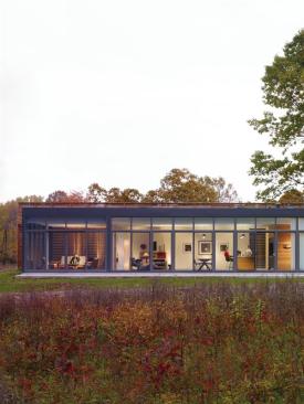 The main living spaces open to a clearing in the woods. 