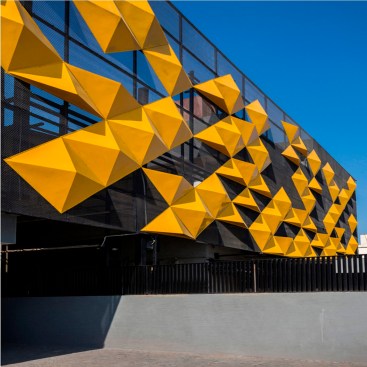The dazzling yellow of the panels provide a suitable contrast to the grey metal mesh.