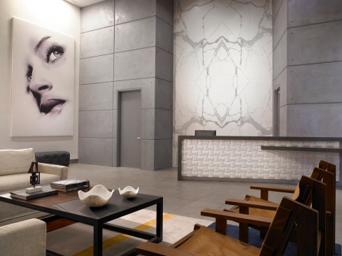 The lobby interiors features intricate wood elements and concrete panels that provide a unique contrast against the bright marble walls.