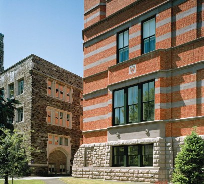 A 1940s two-story addition (top) was demolished to make way for the new addition (above), which connects more uniformly with the existing Hunt building. The new addition carries through original details, such as the rusticated stone base, the brick coloration, and the coping from Hunt's chimneys (built to carry lab exhaust ), while introducing new design elements, such as the cast stone horizontal bands and the tower, meant to play off of the Collegiate Gothic style that dominates the rest of Princeton's campus (opposite).