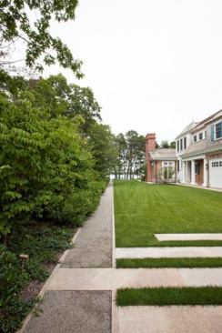Monolithic granite strips on the rear lawn terrace overlap the pathway.