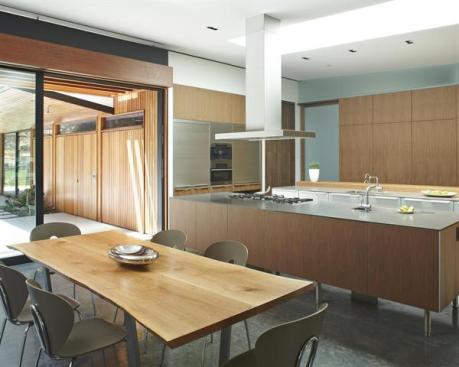 With its walls devoted to storage cabinets and a concealable home office, the kitchen concentrates counter space on two large islands.