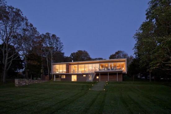 The house floats above its gently sloping, wave-like grassed terraces