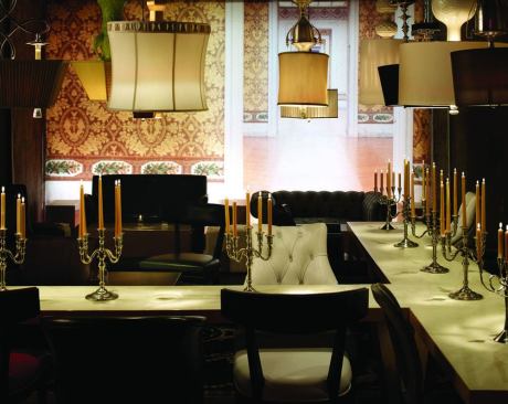 Although no two suspended table lamps in the space are identical, the carefully selected pieces and their arrangement work with the diverse furnishings and finishes to create a cohesive design statement. Matching candelabras provide consistency to assist in unifying the varied d??cor while increasing the intimate feel of the space.