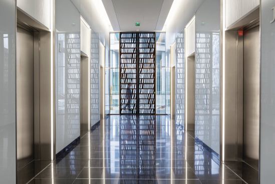The elevator banks feature decorative metal doors that open out on circulation spaces lined in panels from Rheinzink. 