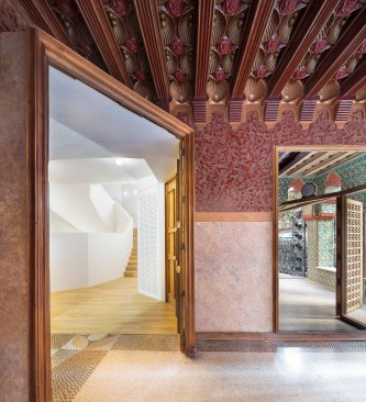 Visitors move directly from the entrance lobby, reflected here in a large mirror, to the newly reinserted stair (shown at left) at the house’s core.