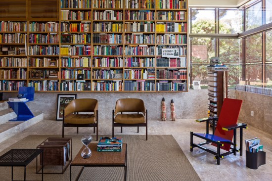 Inside the library, custom shelves hold the client’s 6,000-volume collection, which includes many rare and first edition books. The space also contains a few select pieces from an extensive Modernist furniture collection. The floors in this room, and throughout the house, are Brazilian travertine.
