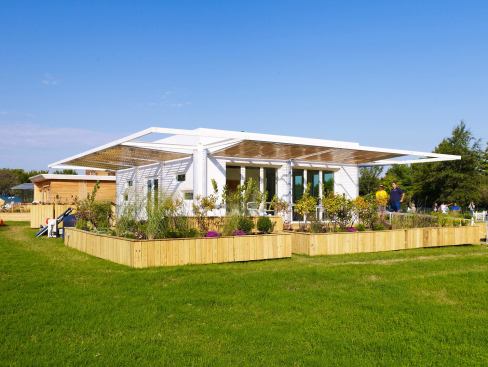 The structure also features an exterior deck with a garden and bioremediating beds that treat stormwater runoff collected from the roof.