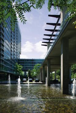 The ground floor of the complex is largely given over to parking, which spills out to the forecourt of the complex. An elevated concrete bridge (at right) serves as a sun deck where residents can lounge and provides shading for guest parking.