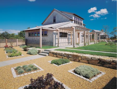 Closet dowels are transformed into fencing and plantings are confined to granite-rimmed squares giving the kitchen herb garden a contemporary edge.
