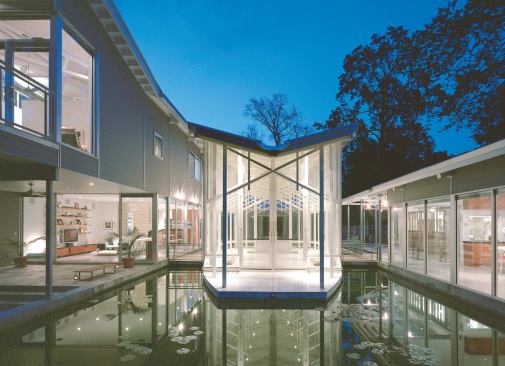 From the rear of the property, the prayer pavilion appears as an ethereal presence between the two houses.