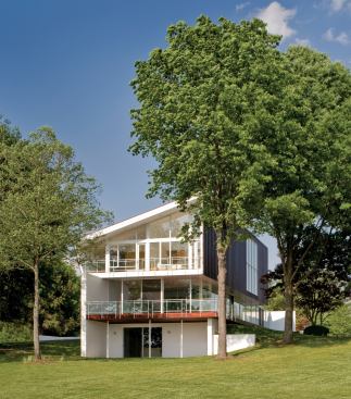 The copper-clad upper level, trapezoidal in section, yields angular interior volumes and expansive views.