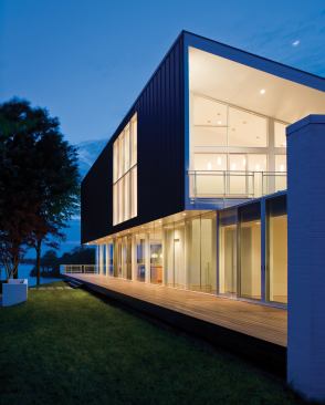 Quiet and reserved at its entrance elevation, this lakeside house opens in dramatic fashion toward the shore.