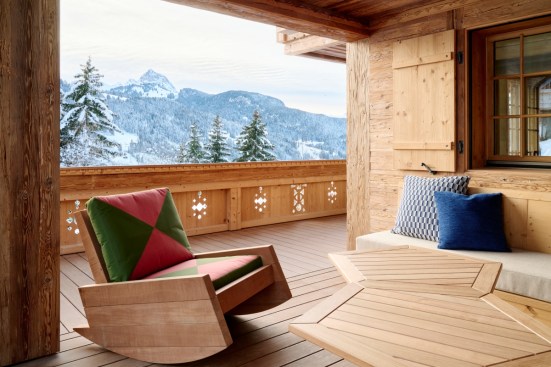 Caption: Balcony overlooking the Swiss Alps with balustrade wood carvings designed by Francis Kéré
