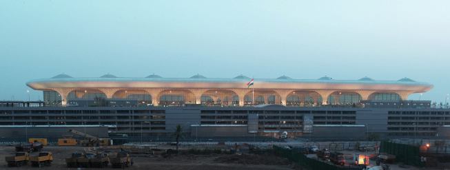 The airport’s long-span steel structure is supported by a grid of composite mega-columns that comprise a 2.3-meter-square cruciform steel structure encased in a 2.7-meter-diameter concrete casing. The panels attach to the structure with a system of aircraft wire and steel hooks molded into the glass-fiber-reinforced gypsum and concrete.