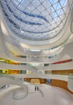 A central atrium connects the three towers in the CJ Blossom Park complex, and it is lined  in amenity spaces outfitted in CJ branded colors.