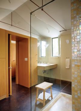 In the master bath, vertical grain Douglas fir linen cabinets flank the access from the adjacent dressing area, linked by a fir lintel over the doorway.