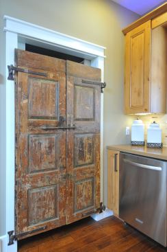 The kitchen gets a unique touch from the teak pantry doors.