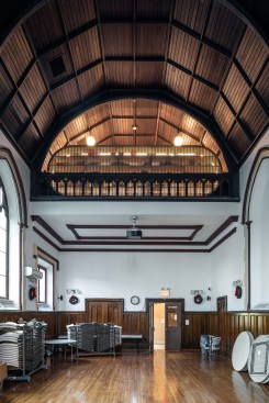 Double-height space with library visible in former choir loft above 