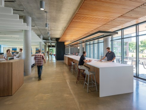 The new addition extends forward, like a ship’s bow, nearly doubling the workspace, while a new entrance reorients the building, better integrating the modern form into the site’s residential setting.