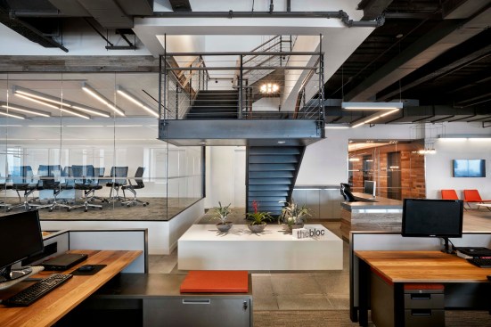 A central staircase adjacent to the reception desk connects to the upper floor, which is home to the Finance, Multimedia, and Graphics groups. 