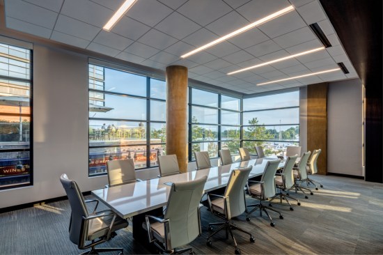 The glass conference rooms incorporate the building’s preexisting, now wax-finished, columns. The weight-bearing columns seamlessly become part of the experience and also sit beside the movable glass partition NanaWall. This system creates the option of expanding or making additional conference space. These rooms escalate sophistication with the surrounding quarter cut Dooge Veneers fumed white oak and Masland carpet from Division 9 Associates.