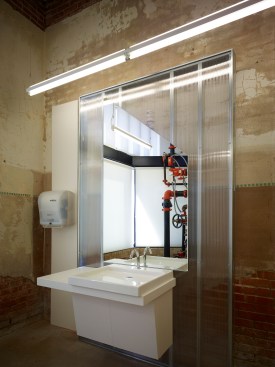 A typical open office space created by clear polycarbonate panels. The perimeter blue panels provide a softened blue hue.  
	
