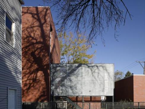 An exterior stair and a detached garage provide privacy at the rear courtyard.