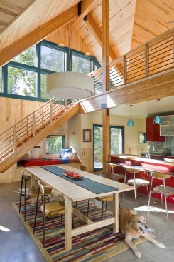 Interior of sunny A-frame cabin showing dining table and staircase