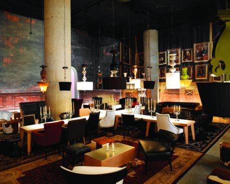 Upside down table lamps and dramatic uplighting behind floor-to-ceiling graphics enhance the whimsical feel of this lounge, which is located at historic Hollywood and Vine Streets. Custom pendant lamps become the eclectic focus decoration, but also provide functional light on the tables below. Energy efficient 20W MR16 fixtures positioned in slots at the base of the room provide subtle ambient lighting as they uplight the wall graphics.