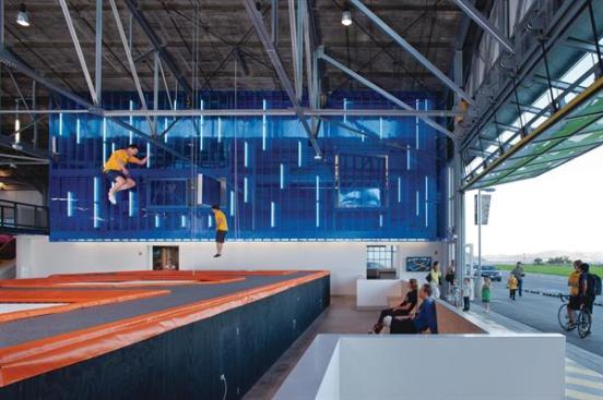 Blue backlit Polygal walls brighten the interior and create brand identity. Pivot doors in the upper-level party rooms allow groups to shut off or take in the raucous atmosphere below.